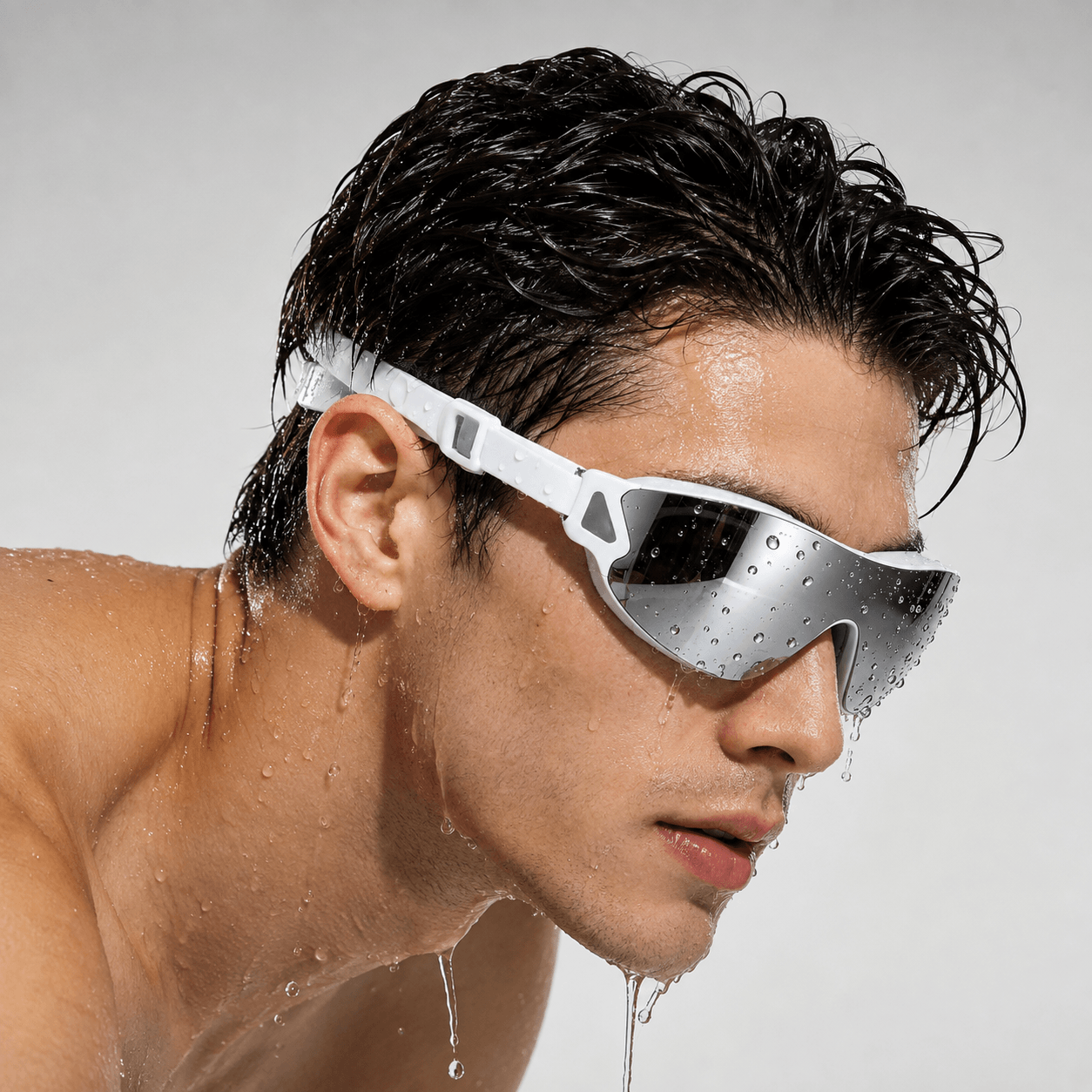 Adult swimmer wearing mirrored prescription swim goggles with water droplets on the lenses and face.
