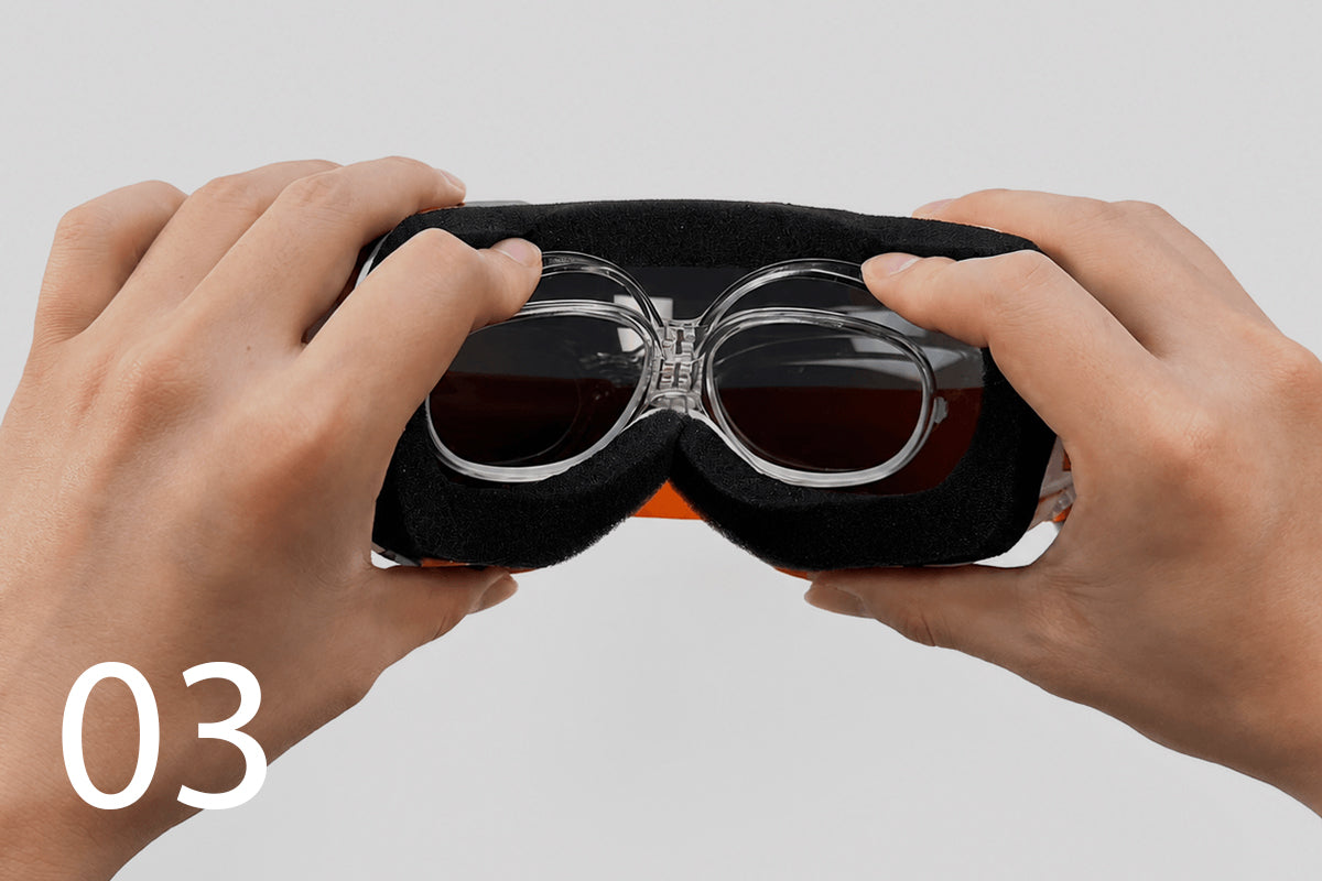 Hands pressing the insert securely into place inside the goggles.
