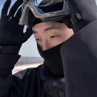 Person wearing sports goggles with a clear prescription insert positioned inside. They adjust the goggles over their eyes to show the insert in use.