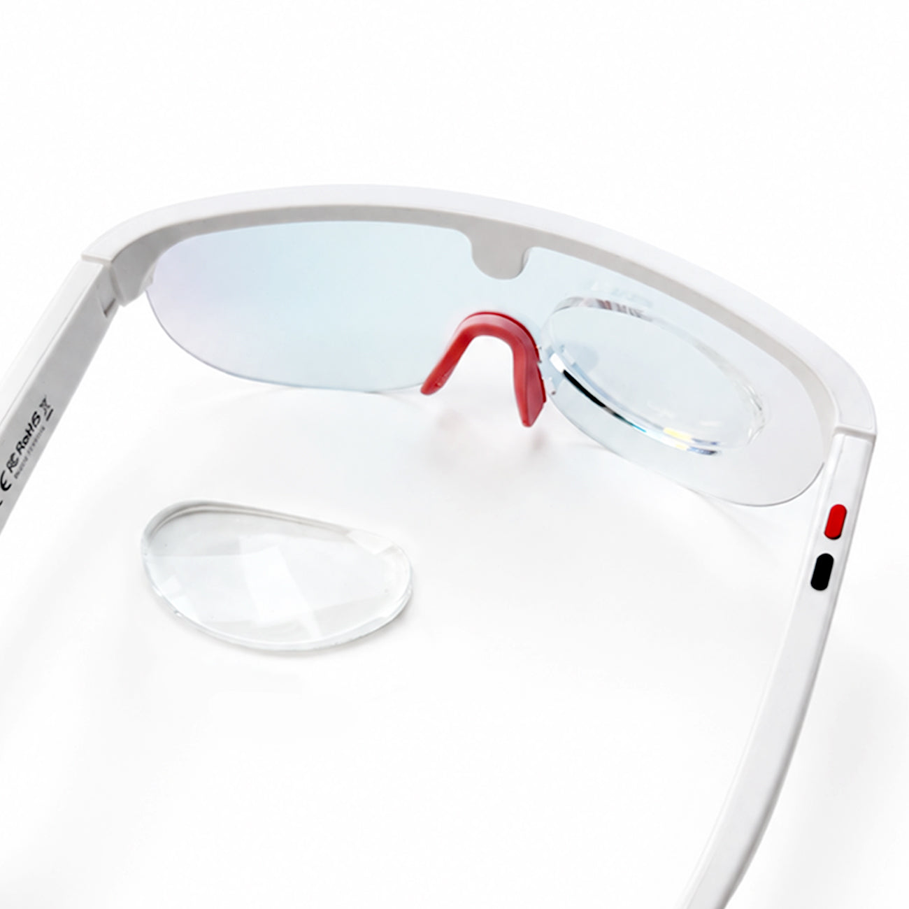 Clear stick on reading lens attached to white ai glasses with a second lens placed beside them.